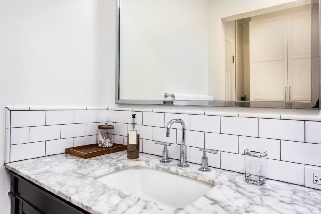 granite bathroom sink countertop with tiled wall